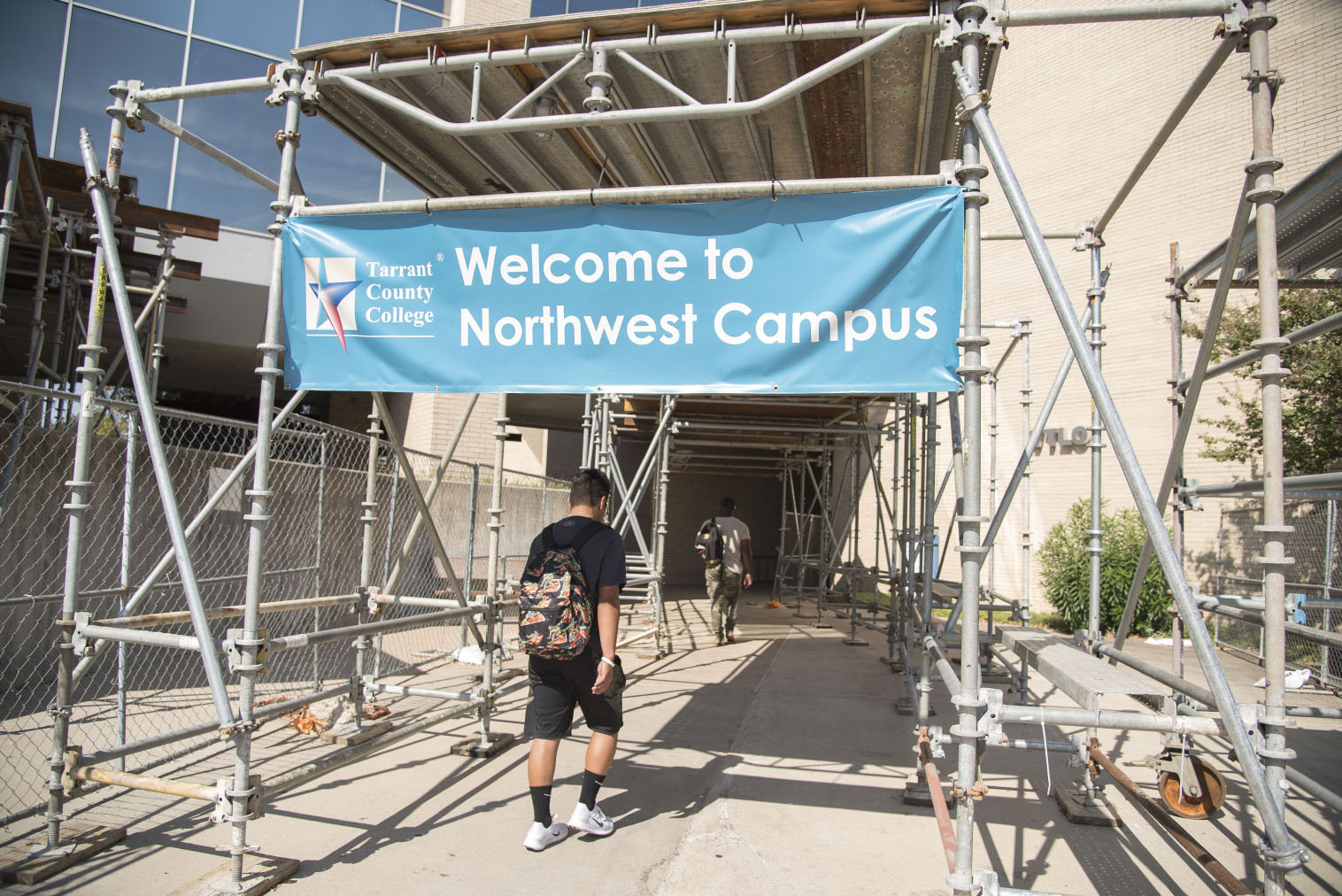 Students walk through a work zone at one of the main entrances near WTLO on NW Campus this fall. Scaffolding and fencing will remain standing for another year while engineers finish an assessment.