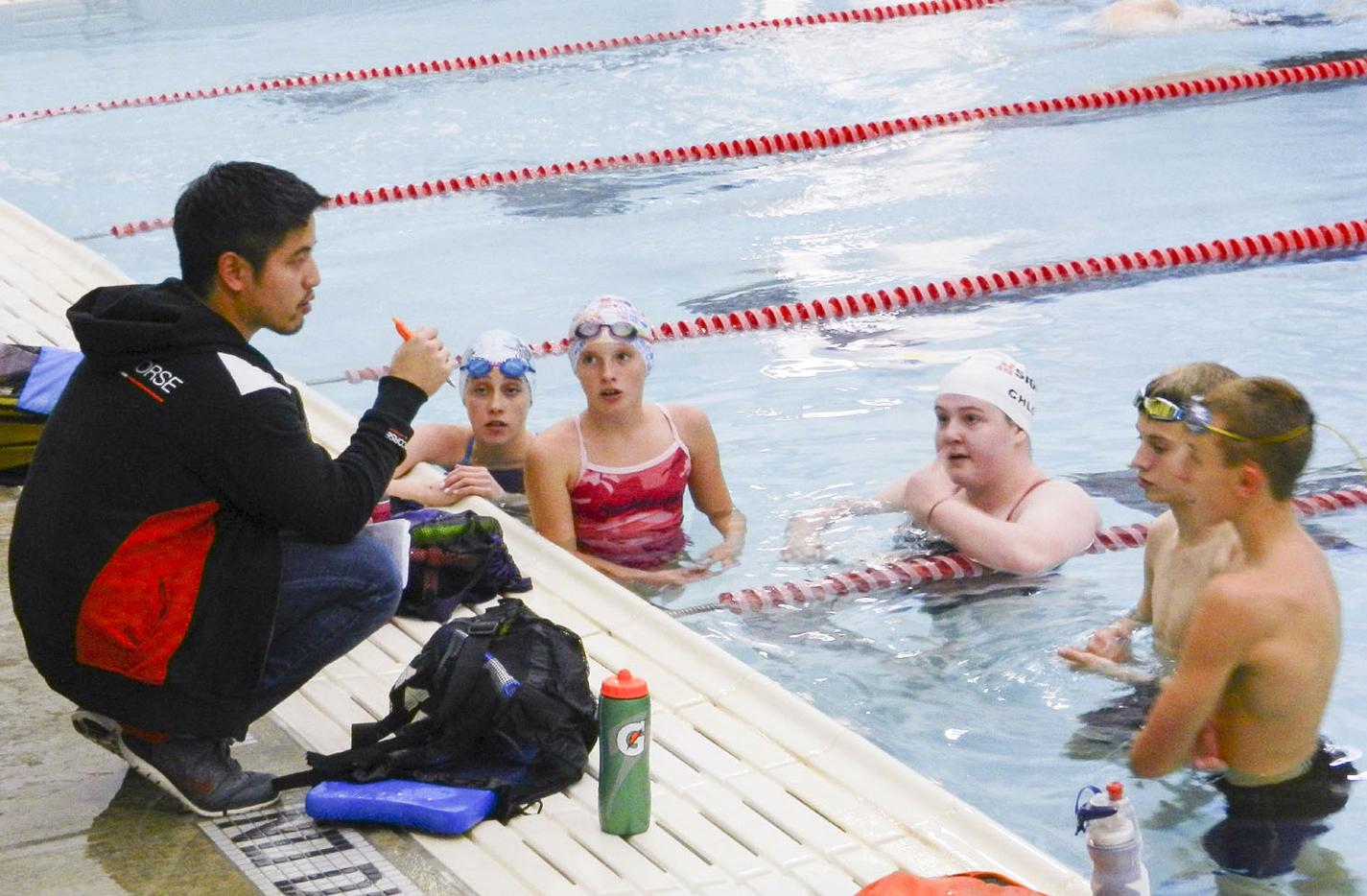 Sigma Swimmers founder and head coach Andrew Ha gives students instructions over technique during a practice session Nov. 9 at the NW pool.