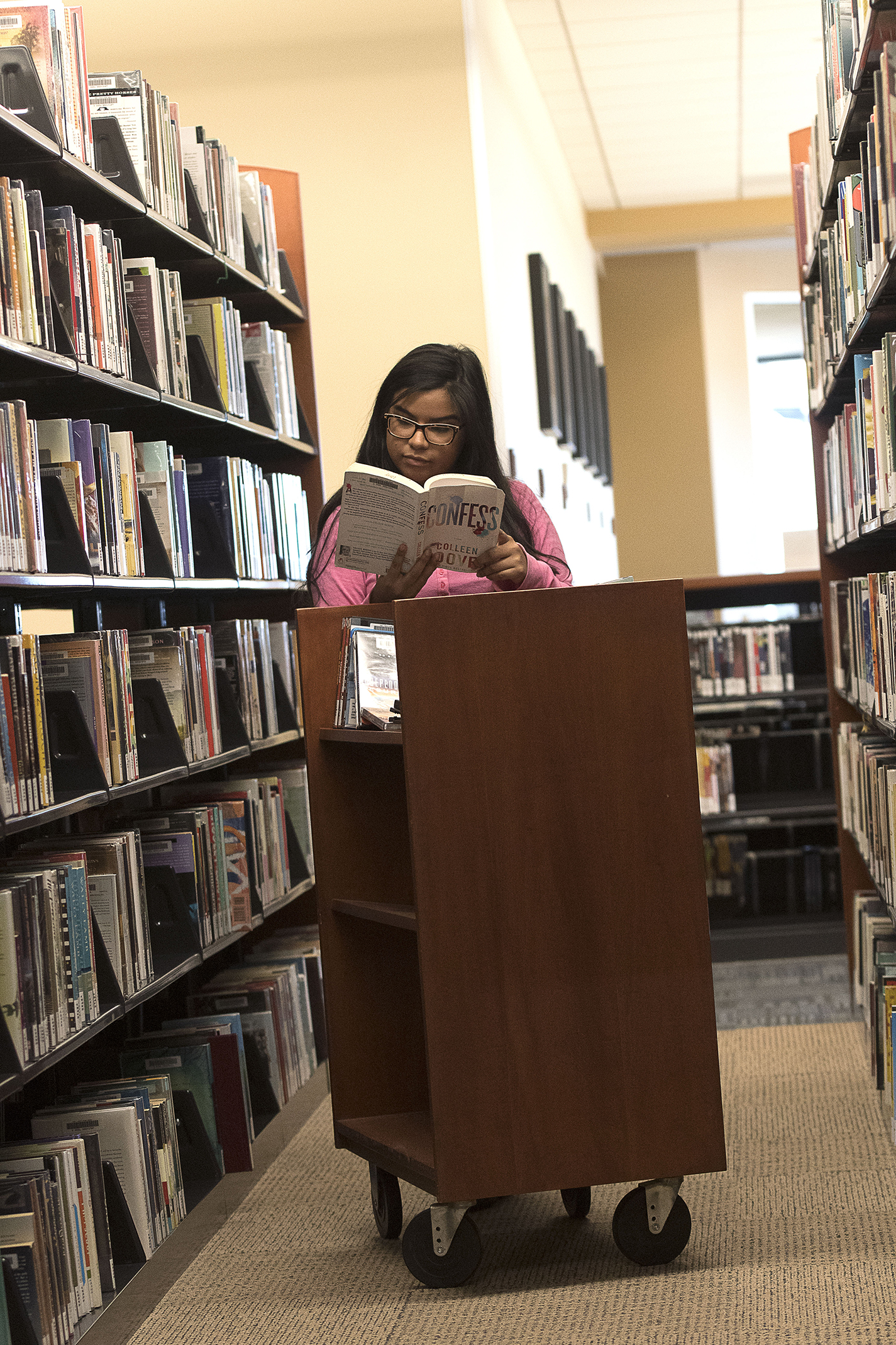 TR work-study student Tatiana Flores skims a book during her library shift.