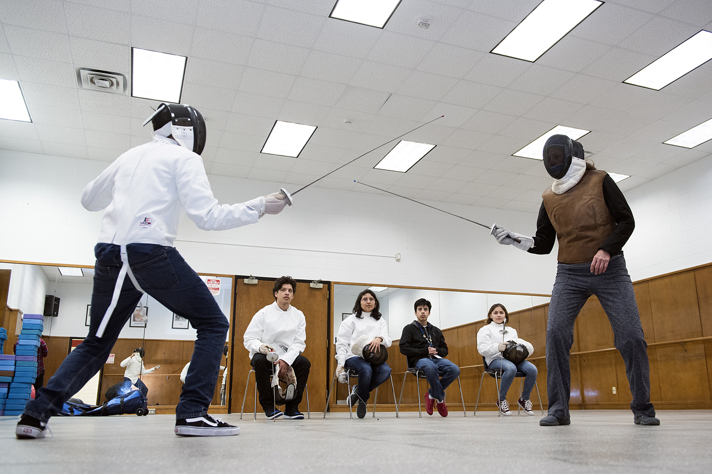 South early college high school student Julio Aguero practices one on one with Vinnie Bradford as other fencing club members observe Feb. 7.