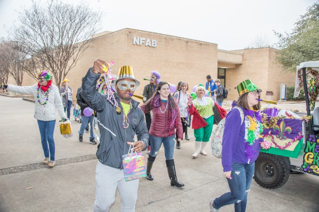 Students passed out goodies and blew noisemakers as they celebrated Fat Tuesday in traditional Mardi Gras masks and costumes for the parade Feb. 13.