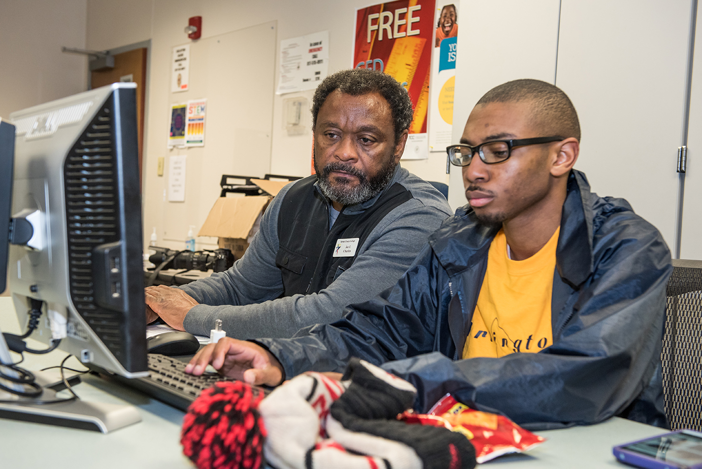 SE coding instructor Joe Charles sits with student Jordan Carter as he works. This class is offered through the campus’ Community & Industry Education office.
