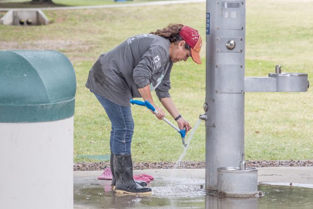 TR library services assistant director Danelle Toups washes off the equipment she used during the kayak cleanup on the Trinity River April 21 for TR’s Campus Day of Service.