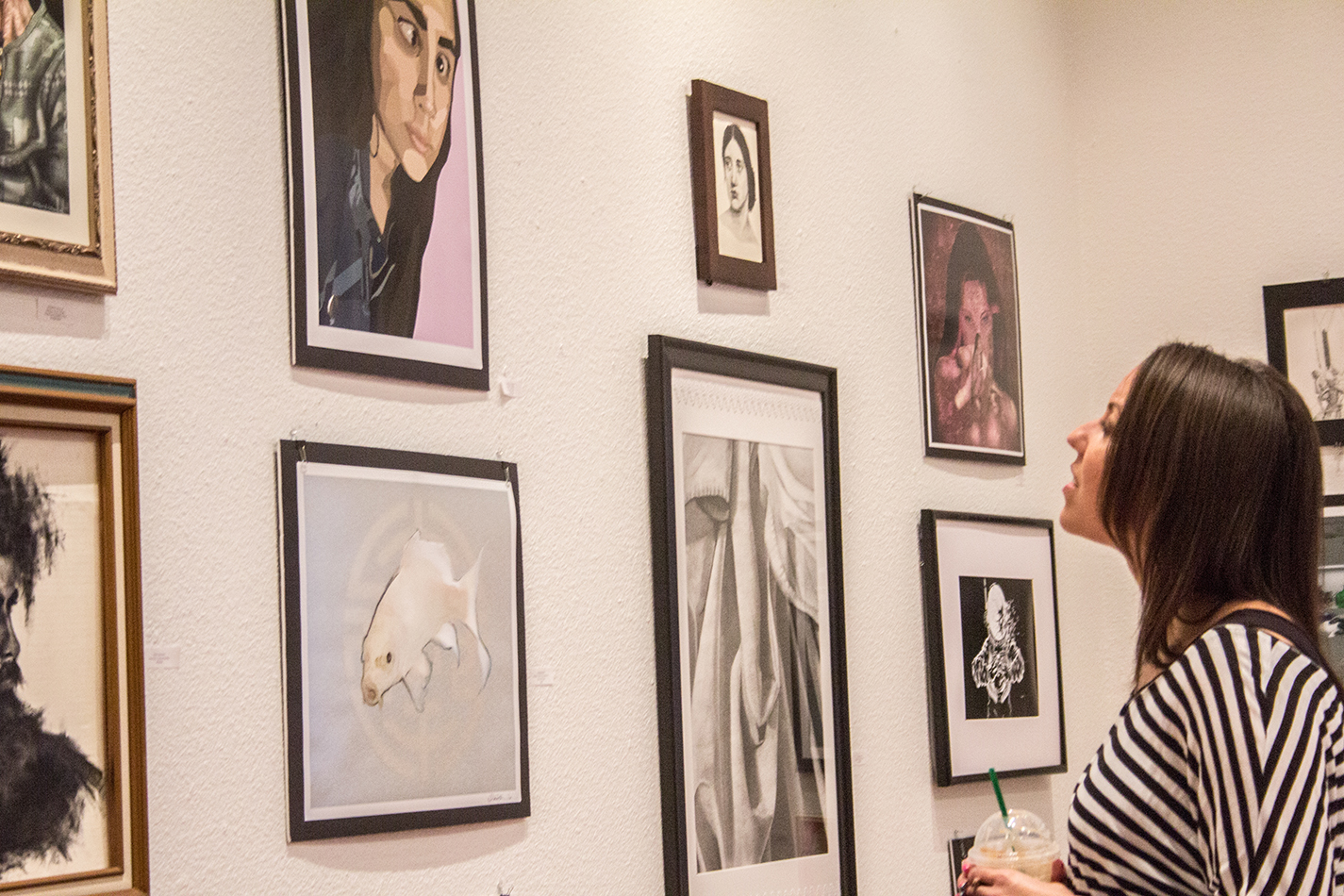 South student Nicole Harris looks at works during the closing reception of the Student Art Show April 26 in the SPAC Carillon gallery on South Campus.