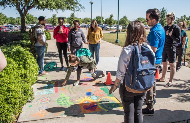SE students work on a group psychology of personality project. Students chalked designs on the walkway between the ESEE and ESED wings on SE Campus.