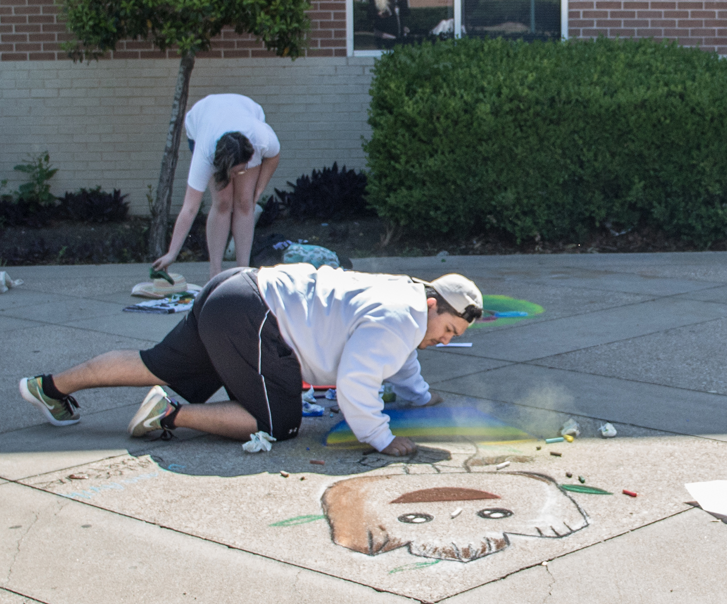 SE student Carlos Martinez participates in Chalk the Walk April 26 on SE Campus. Martinez assisted SE student Diana Avila to complete their section of the walk.