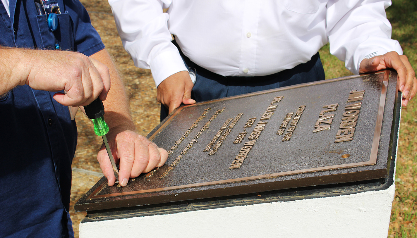 South facilities manager Gus Anderson and carpenter Gary Turnbull open the campus’ 20-year-old time capsule April 19.