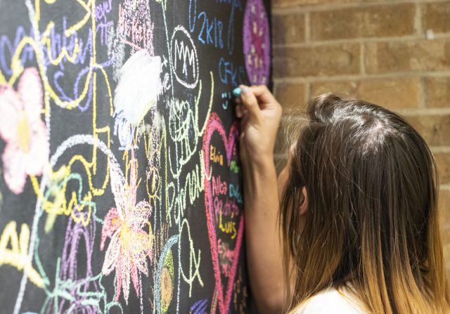 NE student Mindy Bounheuangvulay draws on the art department’s graffiti chalkboard Aug. 24. The wall is a place for students to express themselves visually through their art and connect with fellow artists, said NE art associate professor Martha Gordon.