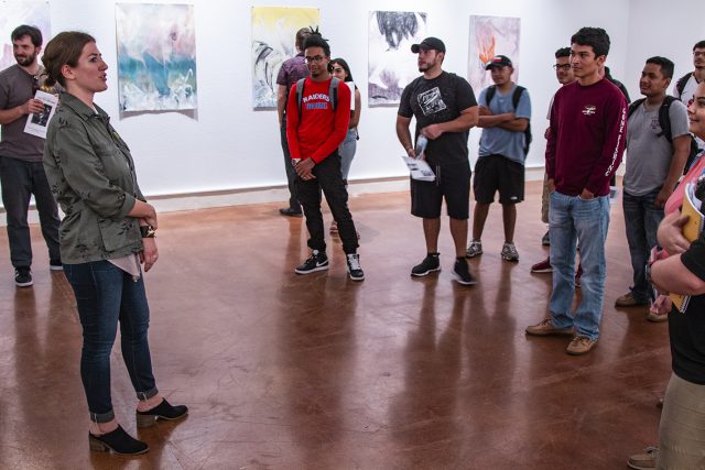 Visual manager Melissa Stoner discusses the prints on display with students during the opening reception for the exhibit Aug. 30 on South Campus.