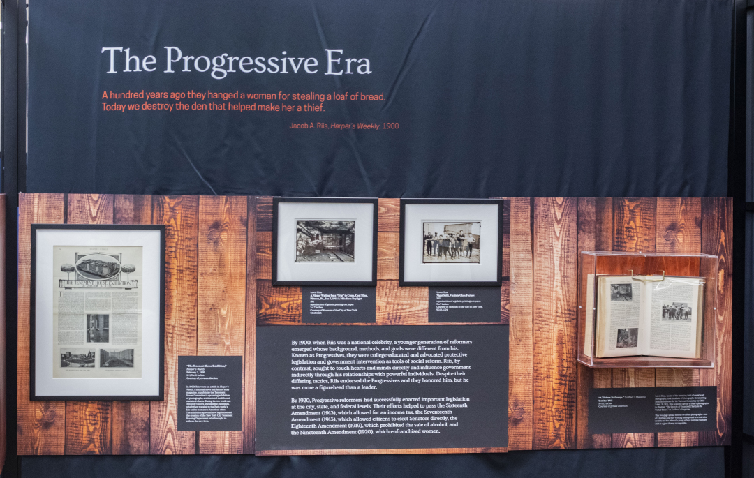 The display shows Jacob Riis influence through literary work with a younger generation of reformers in the 1900s called The Progressives whose impact shaped American history.