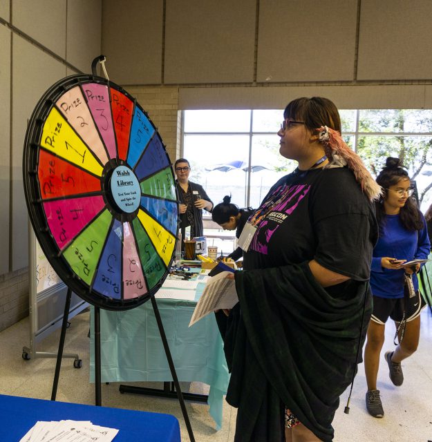 NW student Alexis Wise spins the wheel at the campus library’s booth for a secret prize at Northwest Fest, where students learned about different clubs and departments on NW.