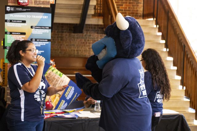 South student development associate Amanda Sims plays a round of rock, paper, scissors with the college’s mascot during the Toro Tailgate Aug. 30.