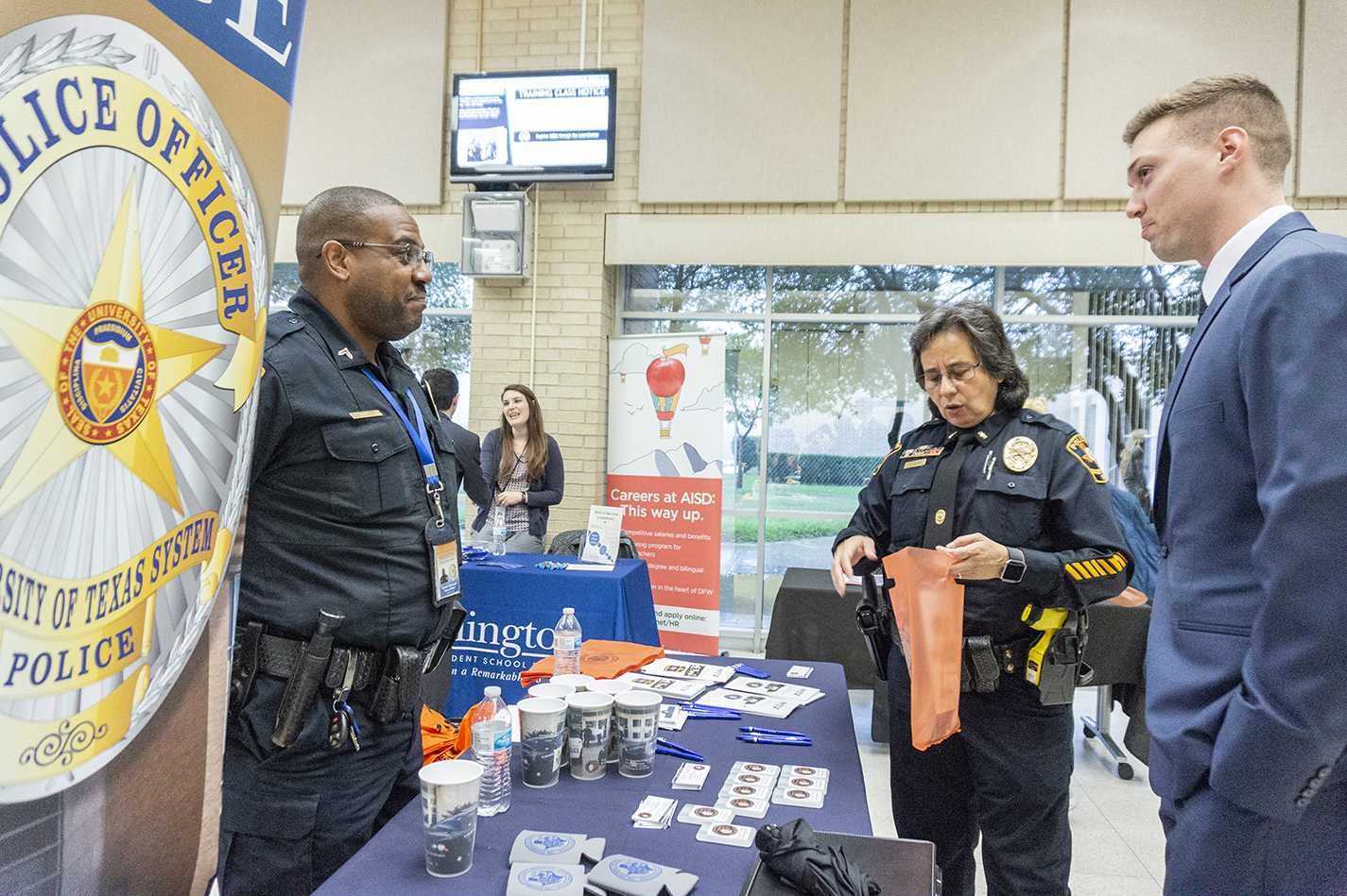Training Cpl. Robert Yarbrough and Lt. Yvonne RoQue give veteran and NW student Alex Harris information about the University of Texas at Arlington police department.