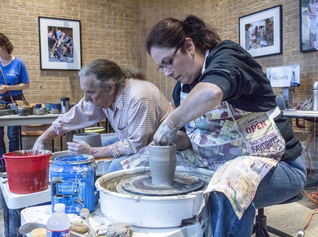 Continuing education instructor Ralph Tobin joined NE student Alison Cohen to make pottery at the Northeast Ceramics Art Pottery Sculptures table during Fall Fest Oct. 18. Hundreds attended the event despite rain moving it inside.