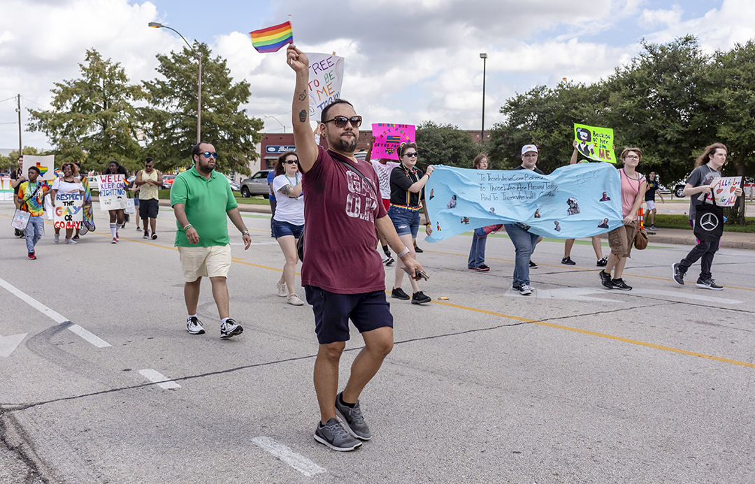 NE financial aid associate Andee Rodriguez waves a pride flag as he marches with other TCC students, faculty and staff carrying banners and posters during the Tarrant County Pride Parade Oct. 6 in downtown Fort Worth.