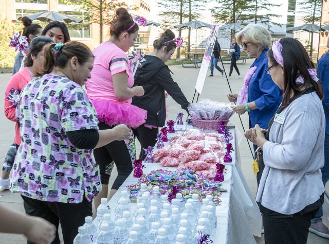 TR students finish the Breast Cancer Awareness Walk, and faculty and staff greet them with goodies including bottled water, popcorn and wristbands.