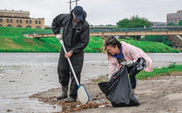 Bad weather did not keep director of student development services Carter Bedford, TR student Susan Su and others from cleaning up trash along Trinity River as part of TR’s “Day of Service” April 12.  Photo by Christian Garza/The Collegian