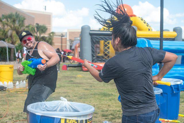 SE student Justin Hinton gets into a water gun fight with another student. There were a variety of activities on multiple campuses, such as dunk tanks, food and prizes for students to get back in the groove of the semester. Photo by Joseph Serrata/The Collegian