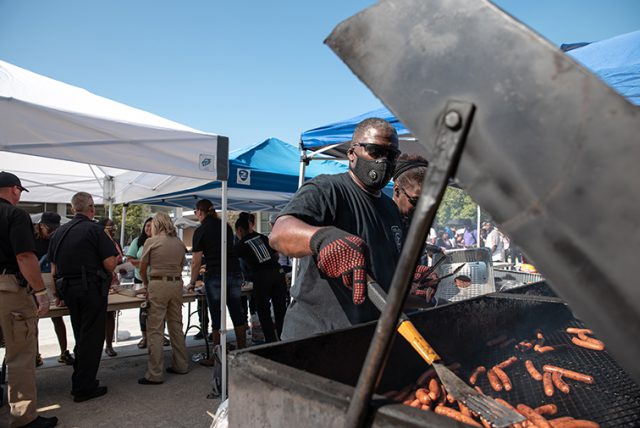 Officer Johnny Holland barbecues hot dogs in preparation for the Cookout with the Cops event. Students and faculty that gathered at South Campus to strengthen community bond.