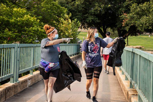 Photos by Azul Sordo/The Collegian 
Alisha Edwards and Diana La walk along the Trinity River bridge looking for trash to pickup at Trinity River’s Trash Bash