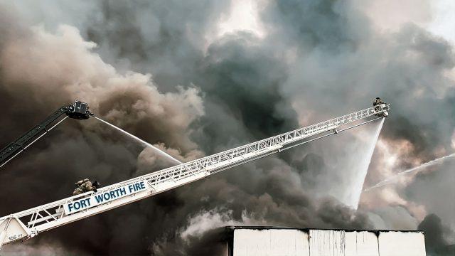 Logan Evans/The Collegian
Firefighters scale a 150-foot ladder to spray the burning Advanced Foam Recycling plant with water.