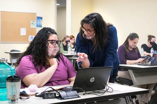Photos by Azul Sordo/The Collegian
American Sign Language instructor Maureen Denner assists TR student Anabel Bernal in making her resume. They wear clear masks to see one another’s facial expressions.