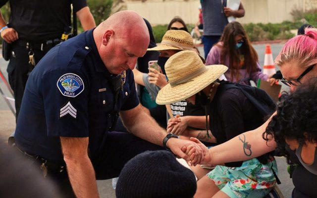 Police officer holds hands in prayer Photo by Eric Yeich Pexel