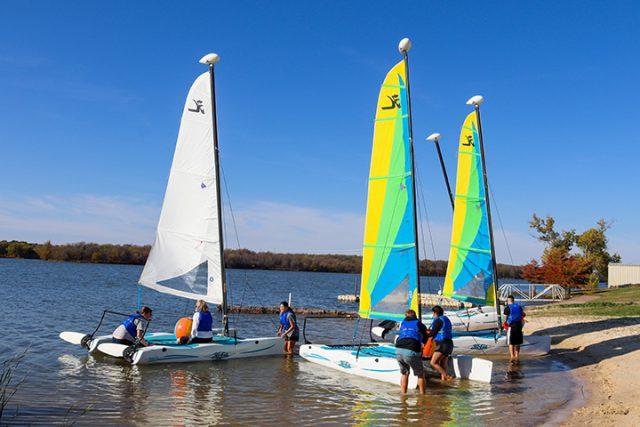 Alex Hoben/The Collegian
Groups of students in Dana Latham’s intro to sailing class push their boats into the lake on NW Campus as they prepare to head into the water. 