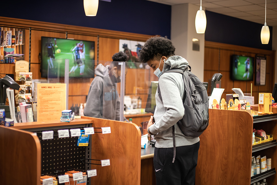 SE student pays at a cash register in the campus shop Feb. 9. Joel Solis/The Collegian