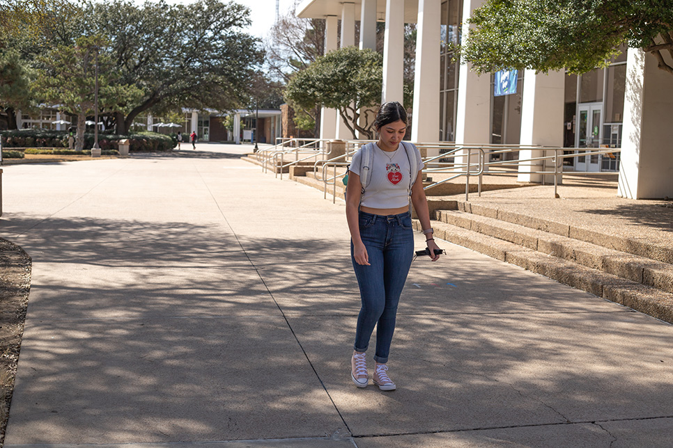South student Nadia Sigala walks in front of the SSTU building on South Campus with a mask in her hand Feb. 10. Joel Solis/The Collegian