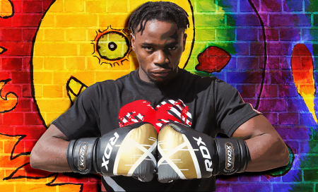 TR student Bisade Afolabi poses with his boxing gloves in front of the album art for his next EP. He is currently taking classes for respiratory therapy. Photo illustration by Alex Hoben/The Collegian