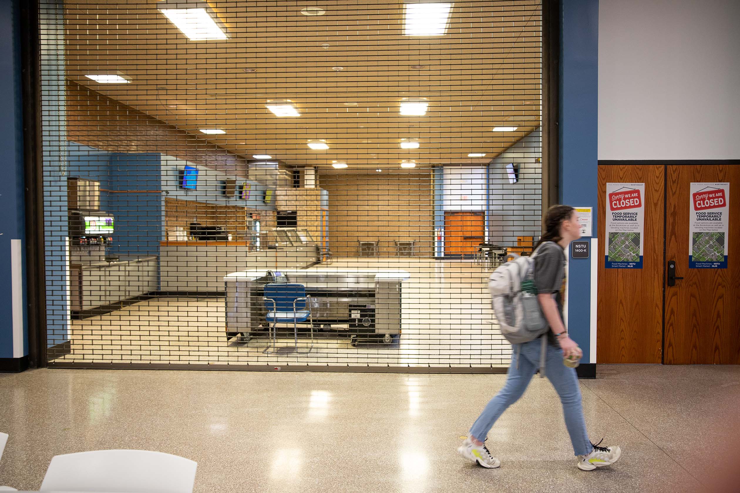 NE student Aly Jones walks by the locked up cafeteria that used to have the Genuine Food food services at NE in the NSTU building. Joel Solis/The Collegian