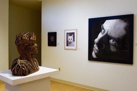 Sebastian Navarro’s pieces “Almost Me” (left) and “The End” (right) facing each other in the front of the exhibit space. They are both self-portraits. Photos by Alex Hoben/The Collegian