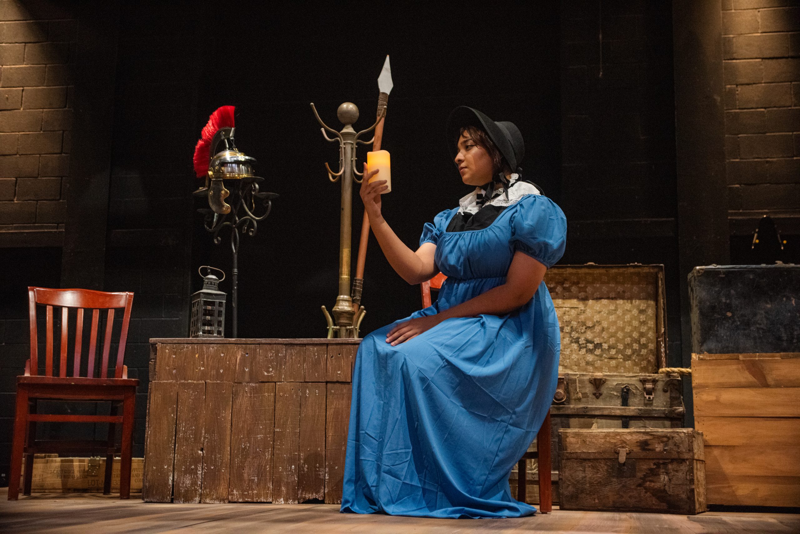 Alex Hoben/The Collegian SE student Isara Al-Hilo poses on-stage with one of the many candles on the set in her costume as the Reverend’s Wife. Al-Hilo plays five parts in the play.