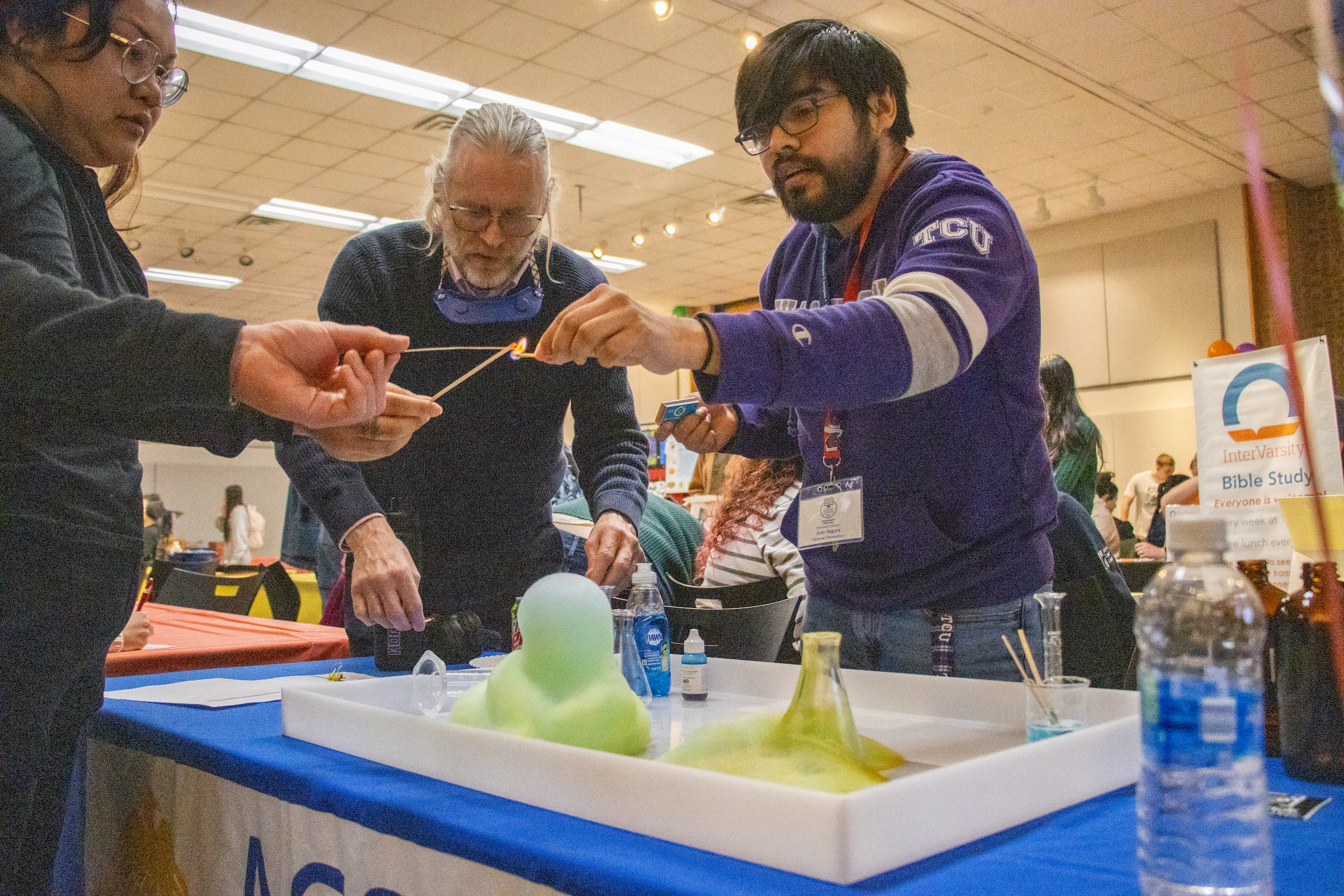 Alex Hoben/The Collegian NE chemistry instructor Steven Rooney and president of the Chemistry Club Juan Segura demonstrate a chemical reaction at the club’s booth during Club Rush. Segura invited various students from the crowd to participate in the experiment.