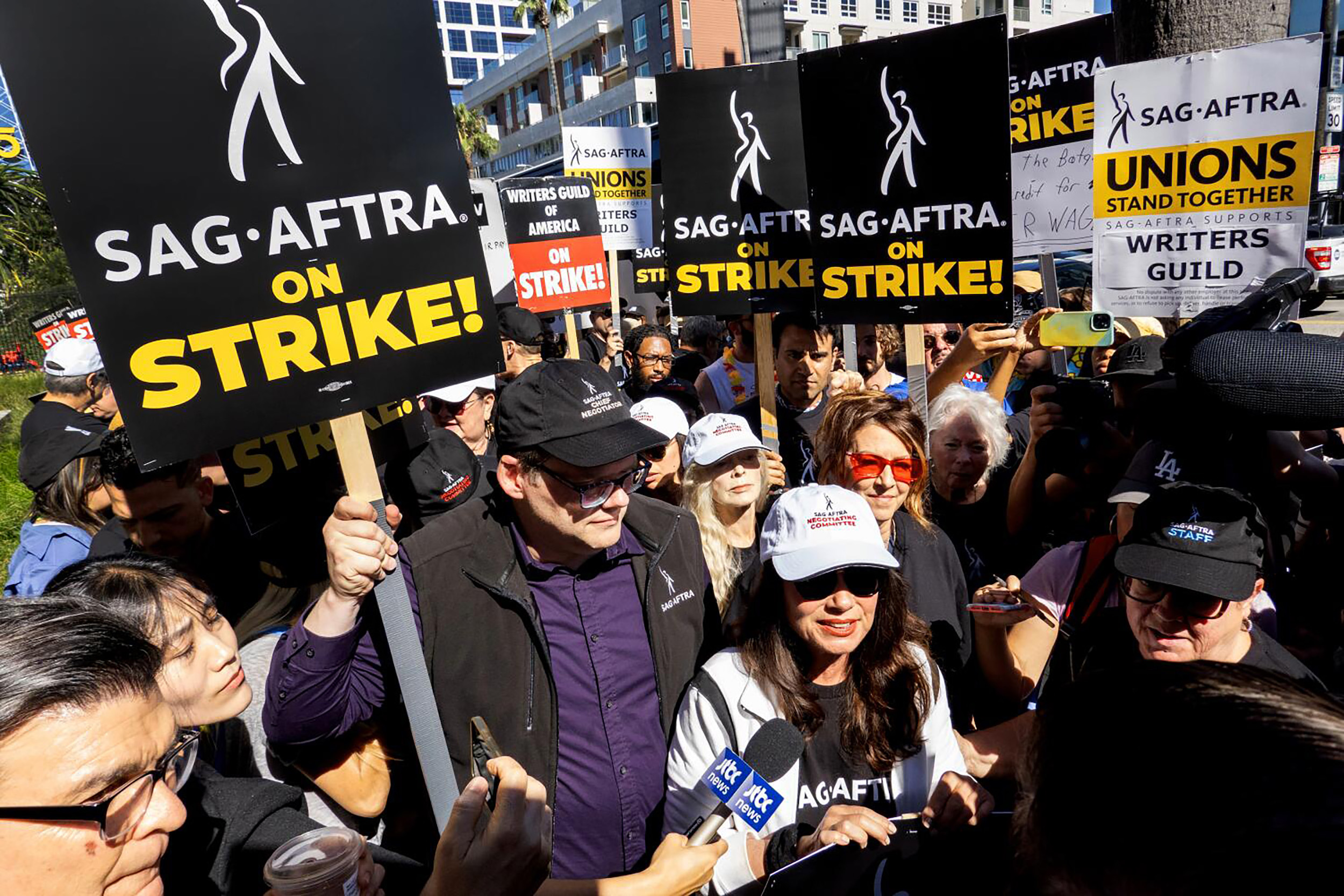Myung J. Chun / Los Angeles Times LOS ANGELES, CA - JULY 14: SAG-AFTRA President Fran Drescher, white cap front, and National Executive Director and Chief Negotiator Duncan Crabtree-Ireland, left, greet picketers at the Netflix picket line in Los Angeles, CA on Friday, July 14, 2023. Actors join striking writers who have been on the picket lines since the beginning of May.