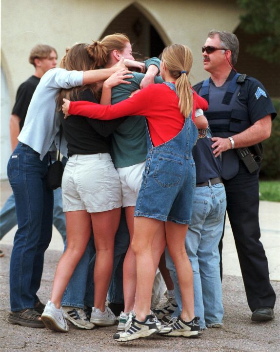 Mark Reis/The Colorado Springs Gazette/TNS Columbine High School students embrace a classmate who ran from the school four hours after shooting.