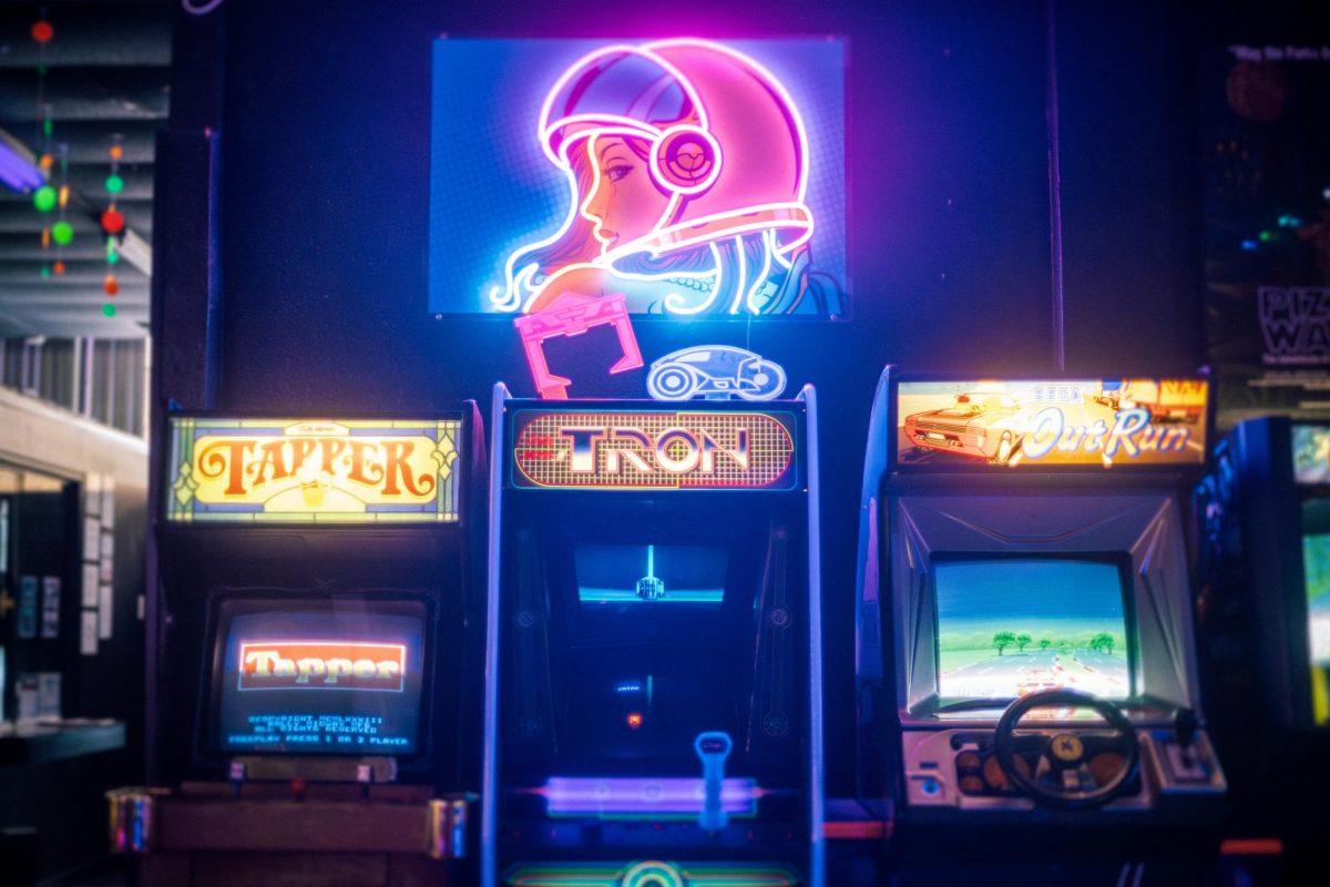 Neon signs surround 1980s-style games at Electric Starship Arcade, a retro arcade and bar in Haltom City that opened in 2020.
