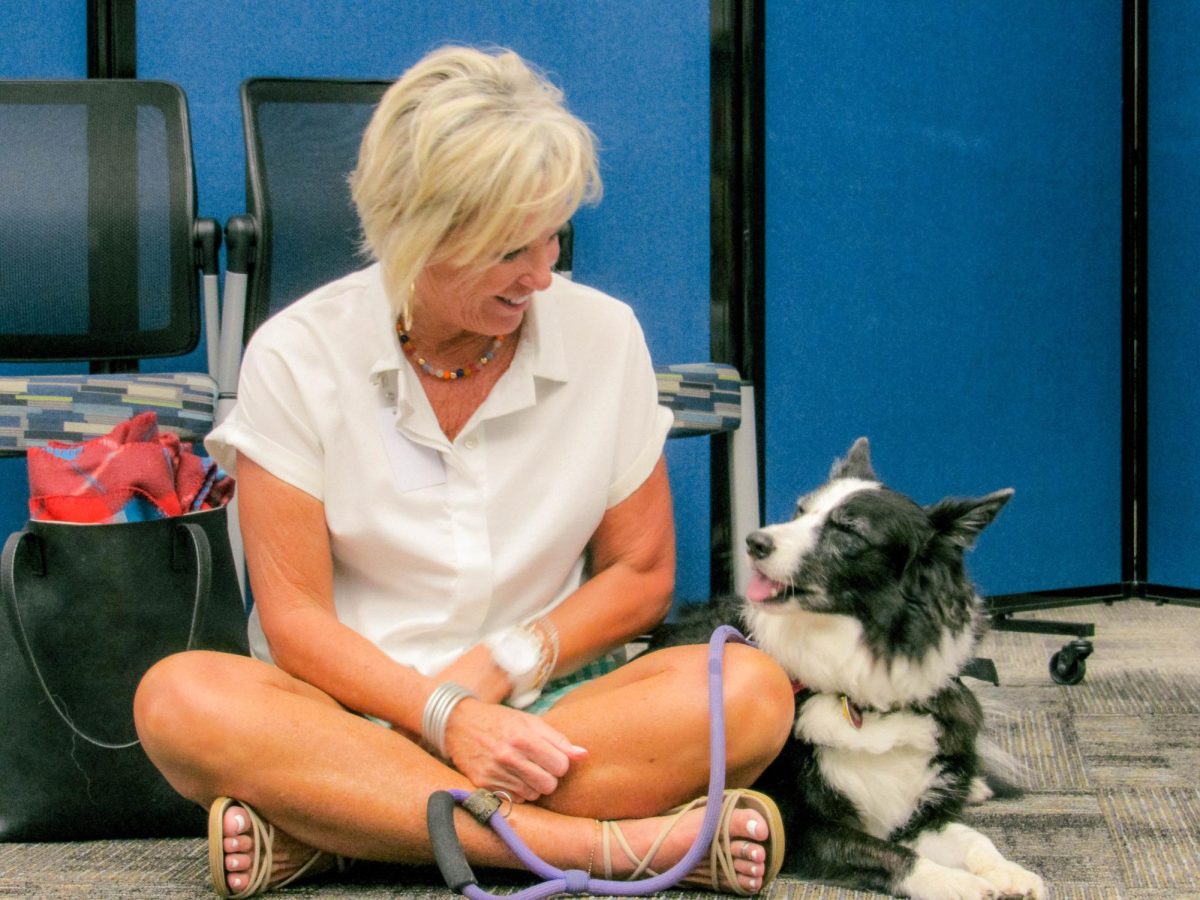 Pet Partners volunteer Nicole Stolle and her therapy dog Sadie wait for the Paws for Wellness event to begin. Sadie has been a therapy dog for six years, often visiting colleges and hospitals.