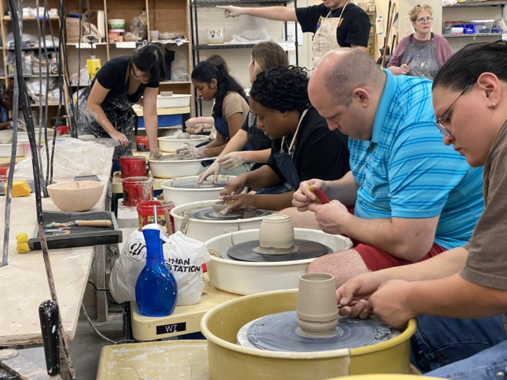 Clay Club members take advantage of the pottery wheels in the studio to mold cylindric pieces.