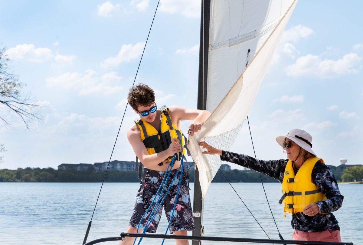 NW student David Lambeth rigs his sail with assistance from class kinesiology instructor Dana Latham on Marine Creek Lake. The class only takes place during fall and summer semesters.