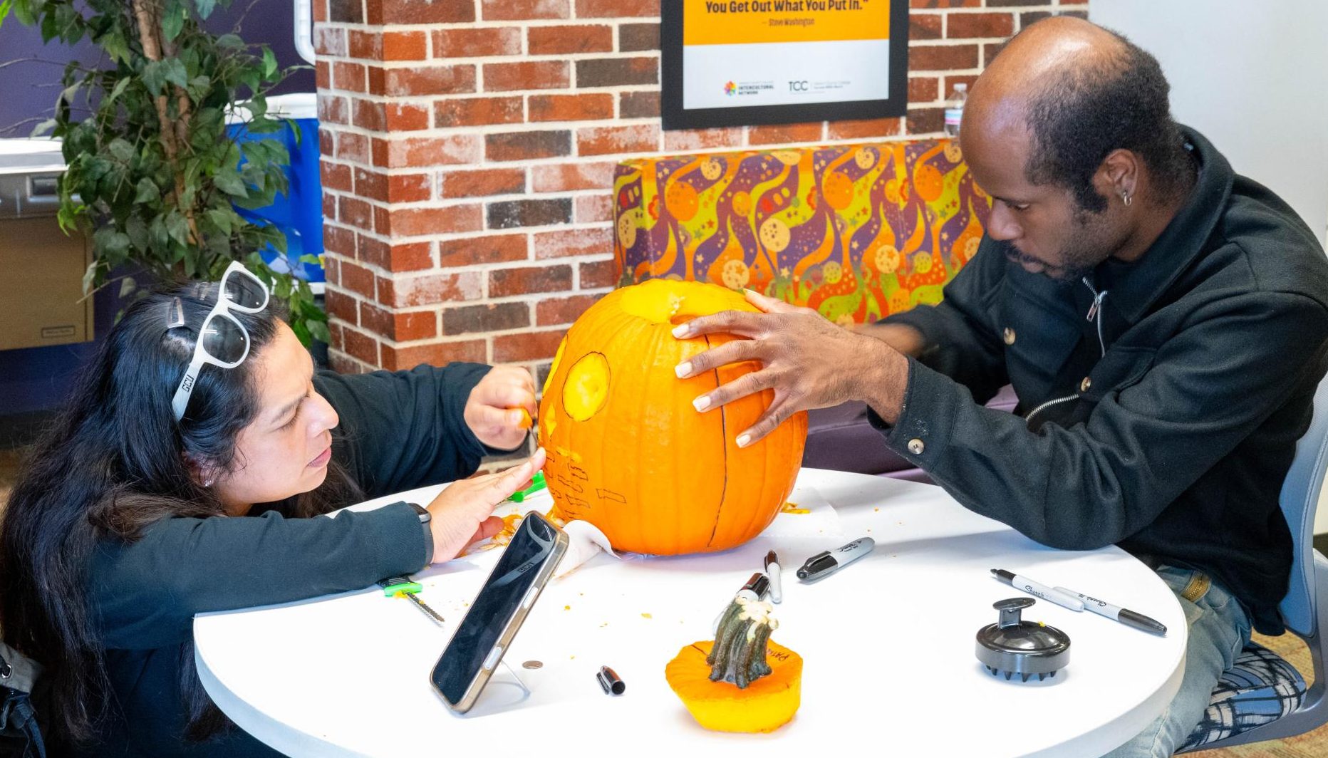 South students Patricia Mansilla and Ladarius Johnson pair up to carve a pumpkin during the Intercultural Network pumpkin carving contest.