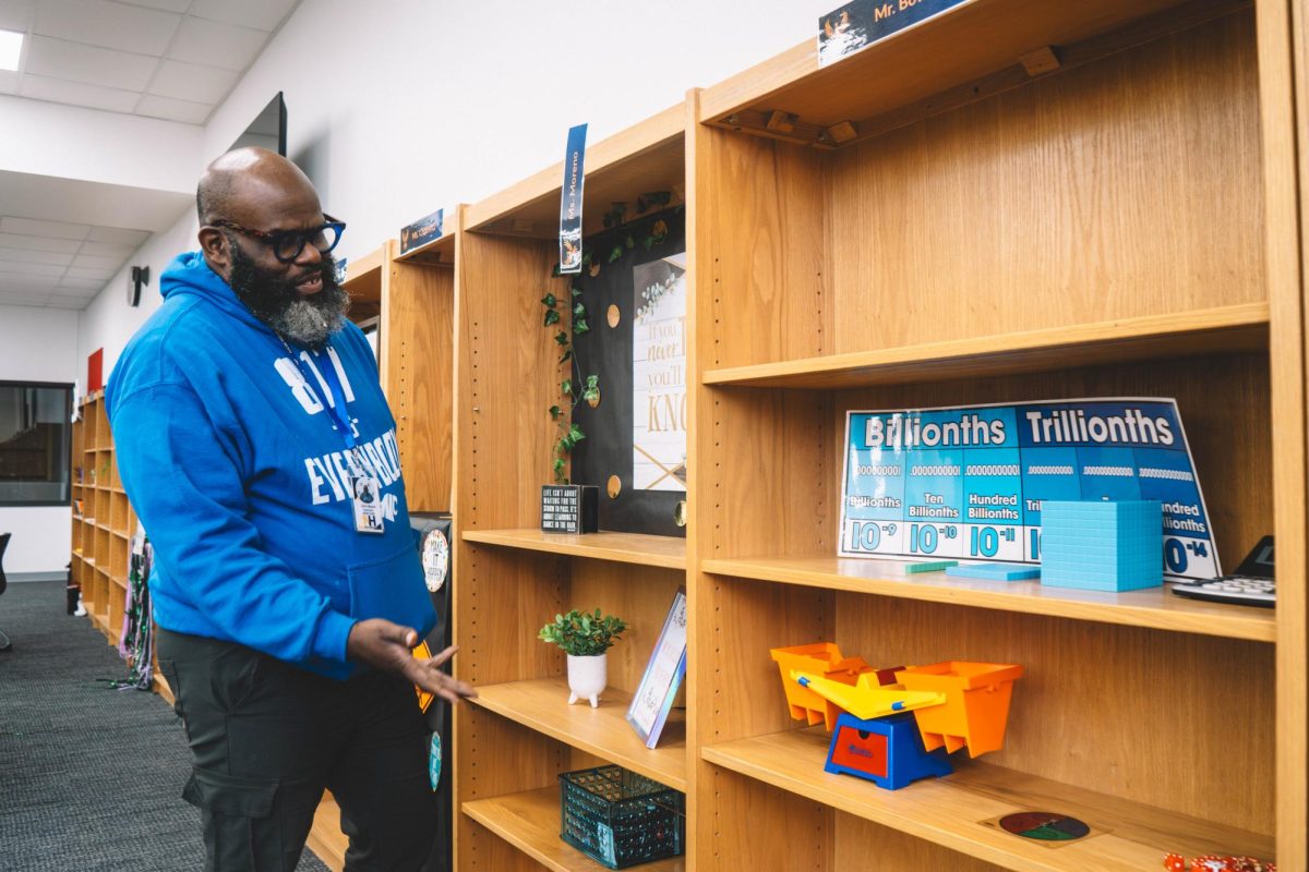 Math instructor of New Heights John Bowie shows his math collection shelf in the Learning Center where students can borrow the items to study.