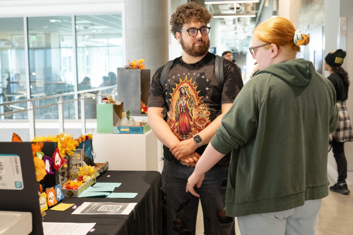 NE student Gabe Tinajero and NW student Sydney Castillo discuss the student-made altars on display in the NW art gallery. 