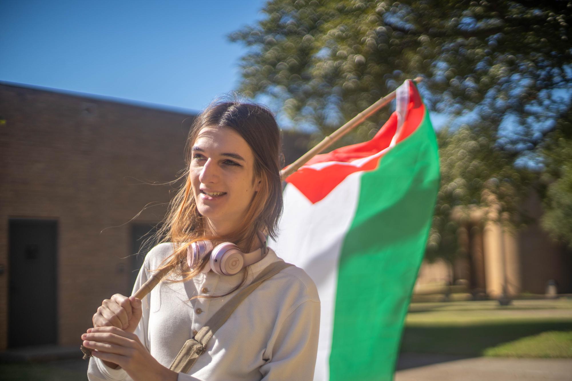 NE student Sasha Crouch strolls around campus holding a Palestinian flag for two to four hours each day on NE Campus to show support for Gaza residents. Crouch times her walks around when classes end. 