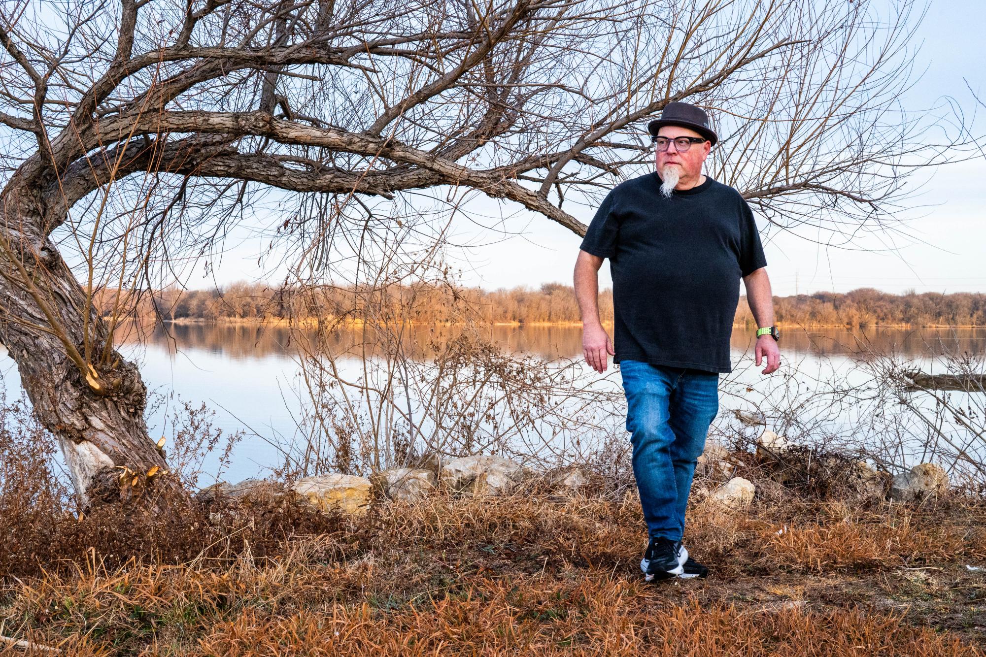 NW assistant professor and artist Kent Anderson Butler walks by a tree featured in his exhibition "Silent Witnesses."