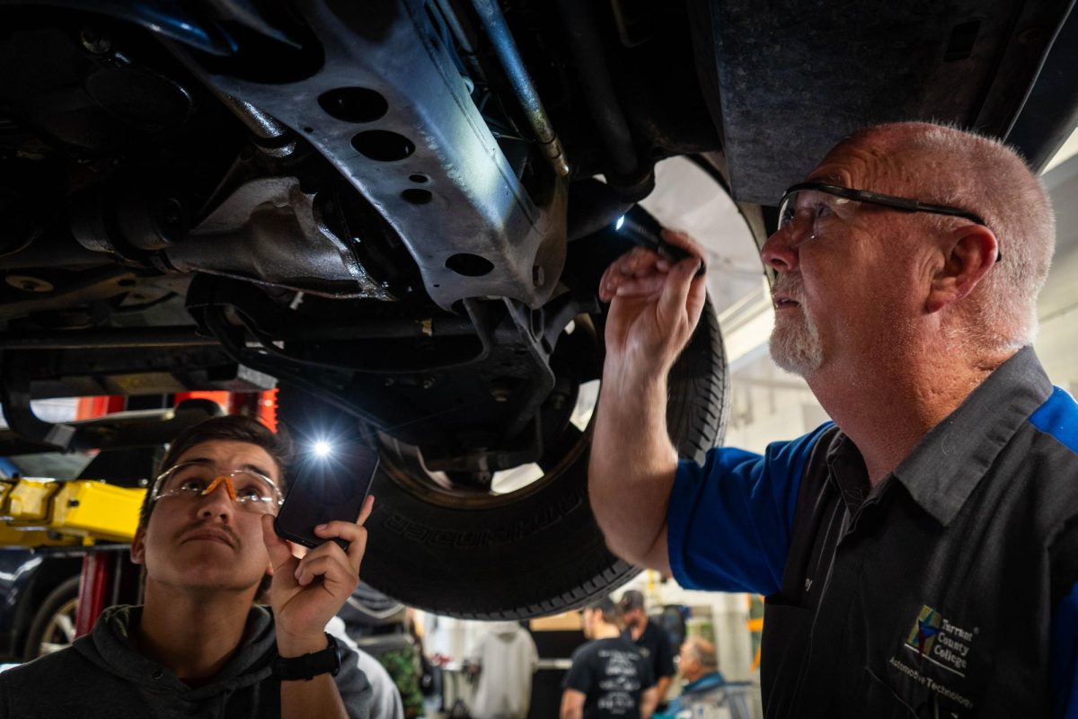 Student Luis Fuentes and instructor Tony Edwards inspecting student Aiden Buckley's 2004 Ford F-150 truck.