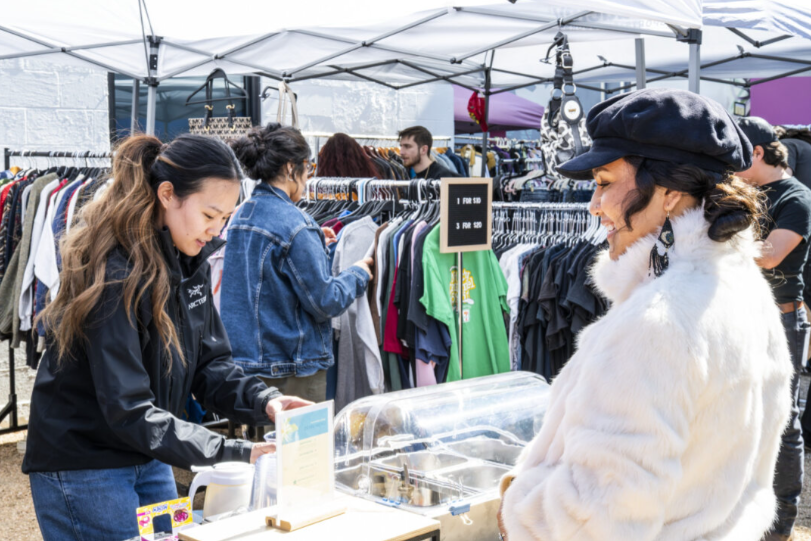 Tees and Teas Vintage associate Kathy Trinh serves customer Jackie Jasso at Doc’s Records outdoor flea market.