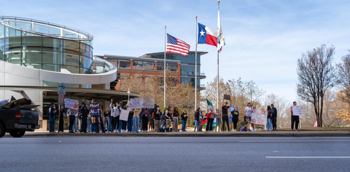 Students display signs to passing motorists on West Belknap Street during an ICE protest on TR Campus on Feb. 25.