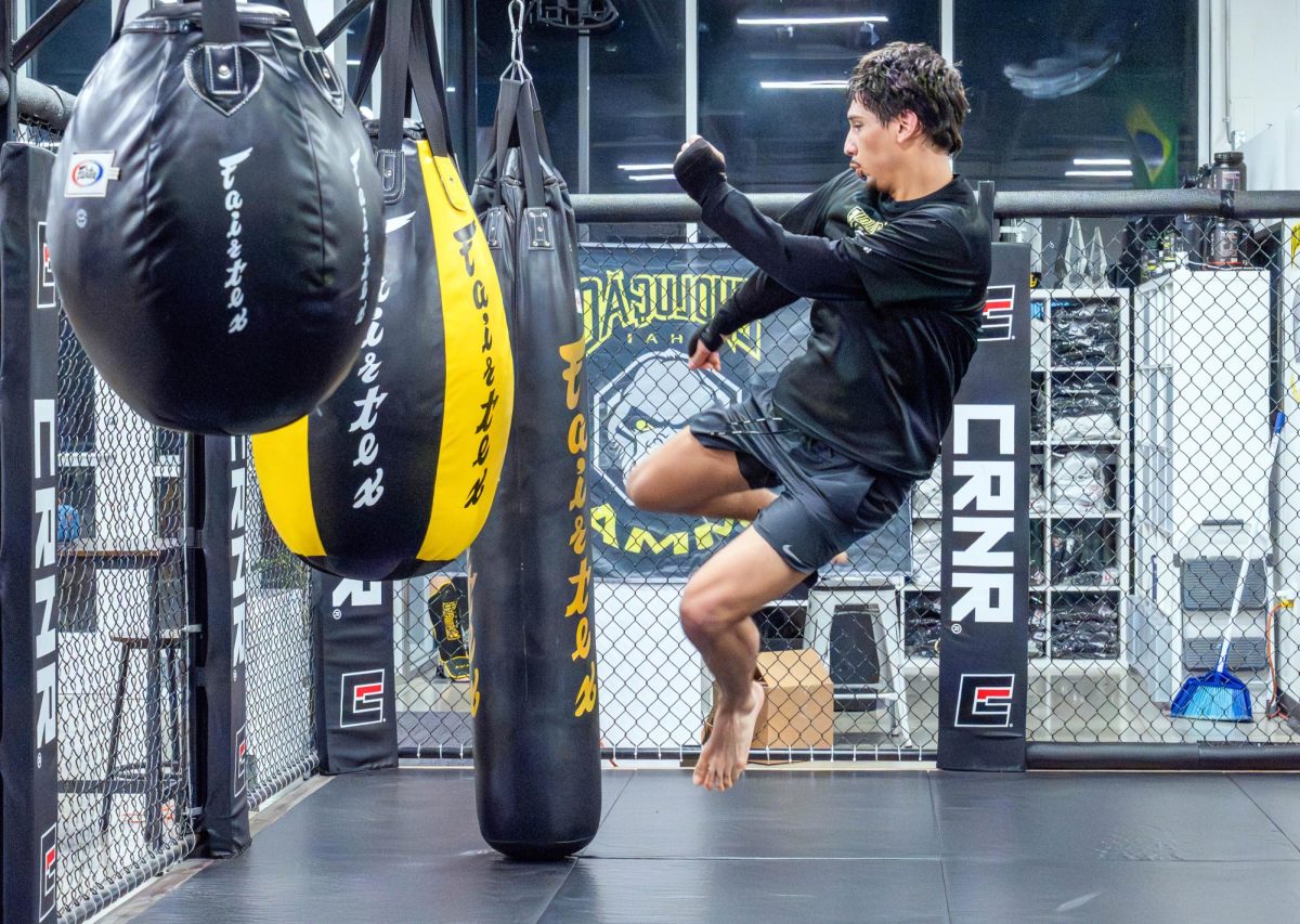 NW student Maverick Diaz warms up on the teardrop bag in his MMA school gym.